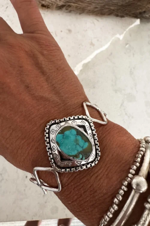 handmade boho style turquoise cuff with. sterling silver hand forged links of various shapes.